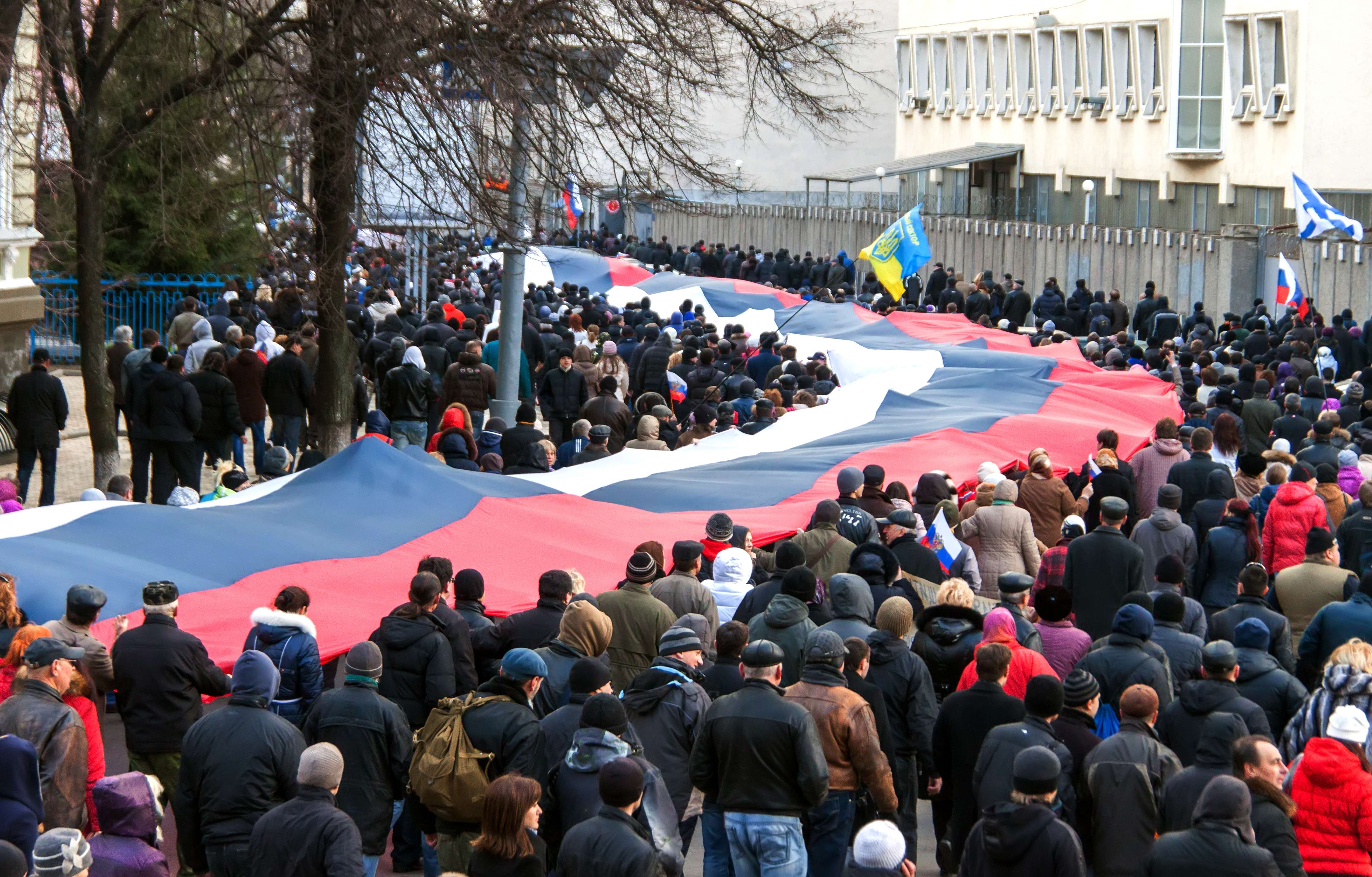 Pro-Russian supporters carry a huge Russian flag during a rally in Kharkiv, eastern Ukraine, some 40 km from the Russian frontier, on March 16, 2014. 6,000 protesters held a "meeting-referendum" to ask for more independence and reclaim the "sovereignty" of the Russian language, on the day Crimea voted to join Russian rule and break away from Ukraine.