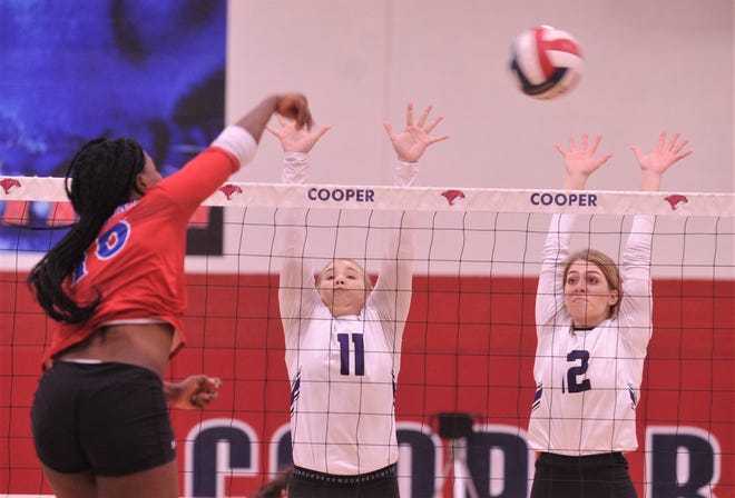 Wylie's Lexi Miller (11) and Madison Burden defend at the net as Cooper's Dazz Larkins hits the ball in the opening game. Wylie beat the Lady Cougars 25-23, 25-17, 25-18 in the District 4-5A match Friday, Oct. 11, 2019, at Cougar Gym.