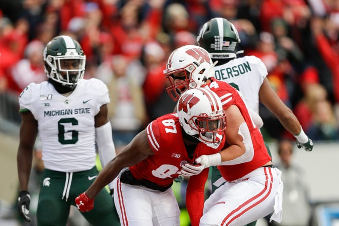 Wisconsin wide receiver Quintez Cephus (87) celebrates a touchdown with teammate Jake Ferguson (84) as Michigan State safety David Dowell (6) and Xavier Henderson (3) look on.