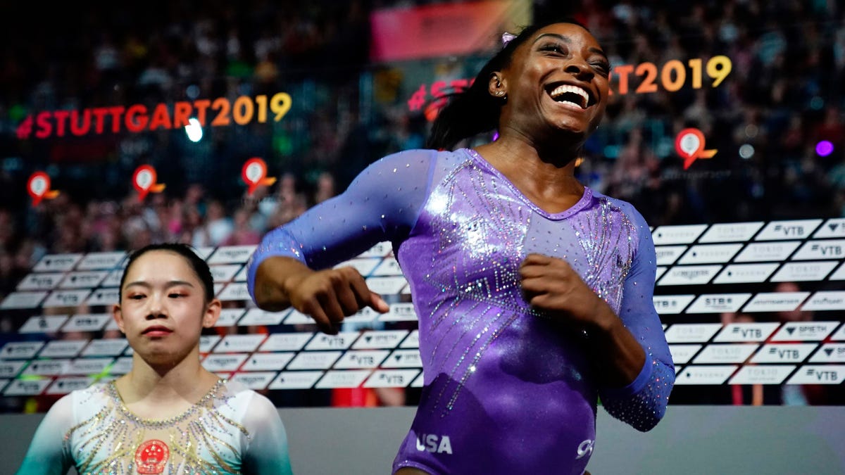Simone Biles celebrates after winning the beam apparatus final as second placed China's Liu Tingting looks on at the Gymnastics World Championships.