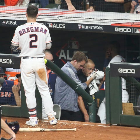 A security guard is tended to in the Astros dugout