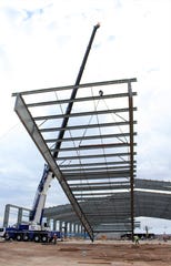 A crane Tuesday slowly lifts a 34,000-pound steel frame, one of 14 pieces that will form the roof structure of the new indoor event center at the Taylor County Expo Center. This was the final piece that would be fitted against No. 13 and bolted together. Oct. 15, 2019