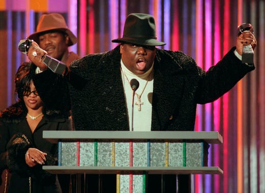 FILE - In this Dec. 6, 1995, file photo, The Notorious B.I.G., who won rap artist and rap single of the year, clutches his awards at the podium during the annual Billboard Music Awards in New York. A New York City street has been named for rapper Notorious B.I.G. Community members and elected officials gathered in a downpour on Monday, June 10, 2019, at the intersection of St. James Place and Fulton Street. (AP Photo/Mark Lennihan, File)