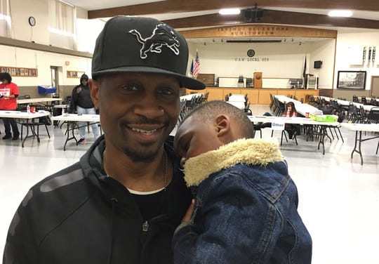 Ricky Callaway, 38, of Flint with his son Carter. Striking. A temporary worker.