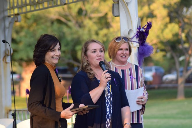 Representatives from Cherished Families speak after accepting an award during an event at Vernon Worthen Park in St. George marking this month as Domestic Violence Awareness Month.