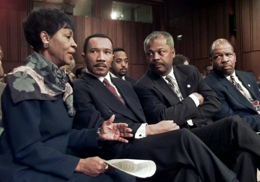Rep. Maxine Waters, D-Calif., talks to NAACP President Kweisi Mfume, Rep. Donald Payne, D-N.J., and Rep. Elijah Cummings, D-Md., as they watch a hearing on allegations of CIA involvement in drug trafficking before the Senate Intelligence Committee Nov. 26, 1996, on Capitol Hill. 