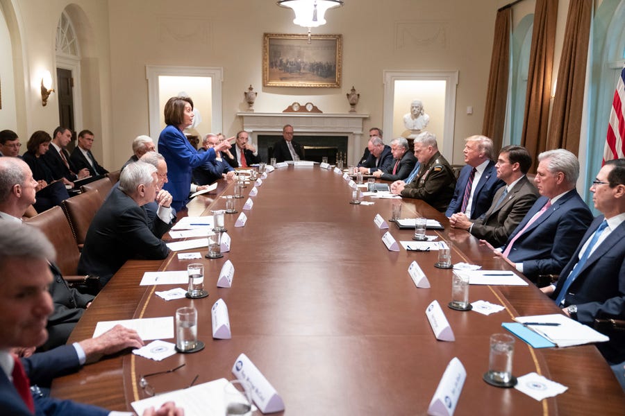 In this photo released by the White House, President Donald Trump, center right, meets with House Speaker Nancy Pelosi, standing left, Congressional leadership and others, Wednesday, Oct. 16, 2019, in the White House.
