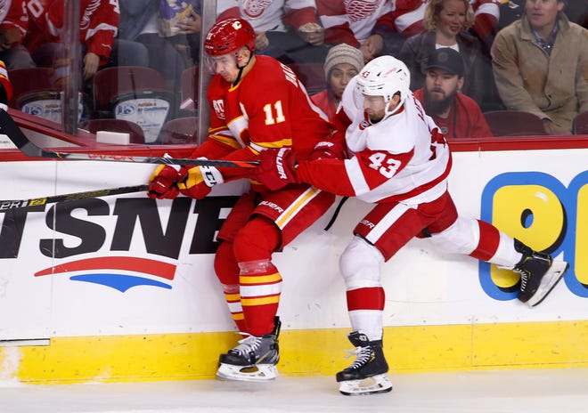 Red Wings center Darren Helm (43) uses his stick to slow down Flames center Mikael Backlund on Thursday.