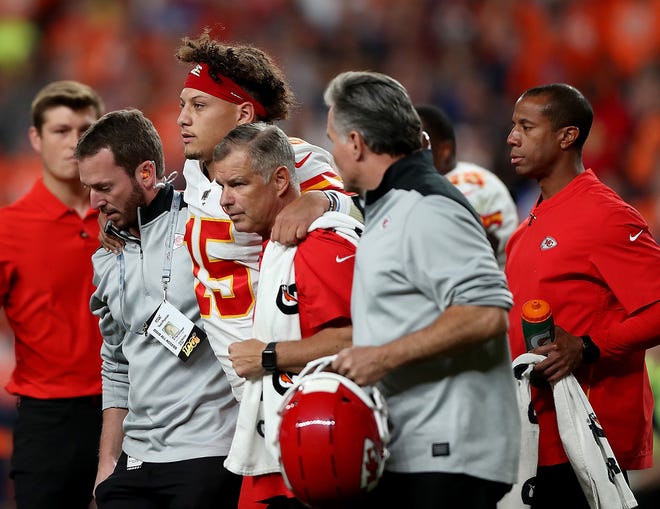 Quarterback Patrick Mahomes (15) of the Kansas City Chiefs is escorted off the field after a knee injury in the first half Thursday against the Denver Broncos.