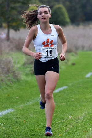 Katie Carothers finished fourth in 18:40.0, leading Brighton to the KLAA girls cross country championship at Huron Meadows Metropark on Tuesday, Oct. 17, 2019.