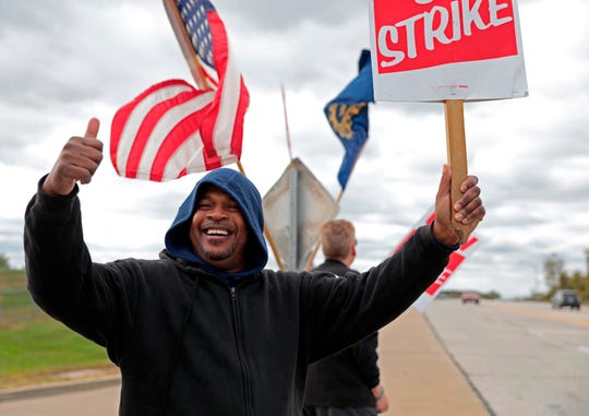 Bill Jackson, of St. Louis, gives a thumbs up to drivers as United Auto Workers members walk a picket outside General Motors Co.'s Wentzville Assembly Center in Missouri. The six-week strike ended Friday.
