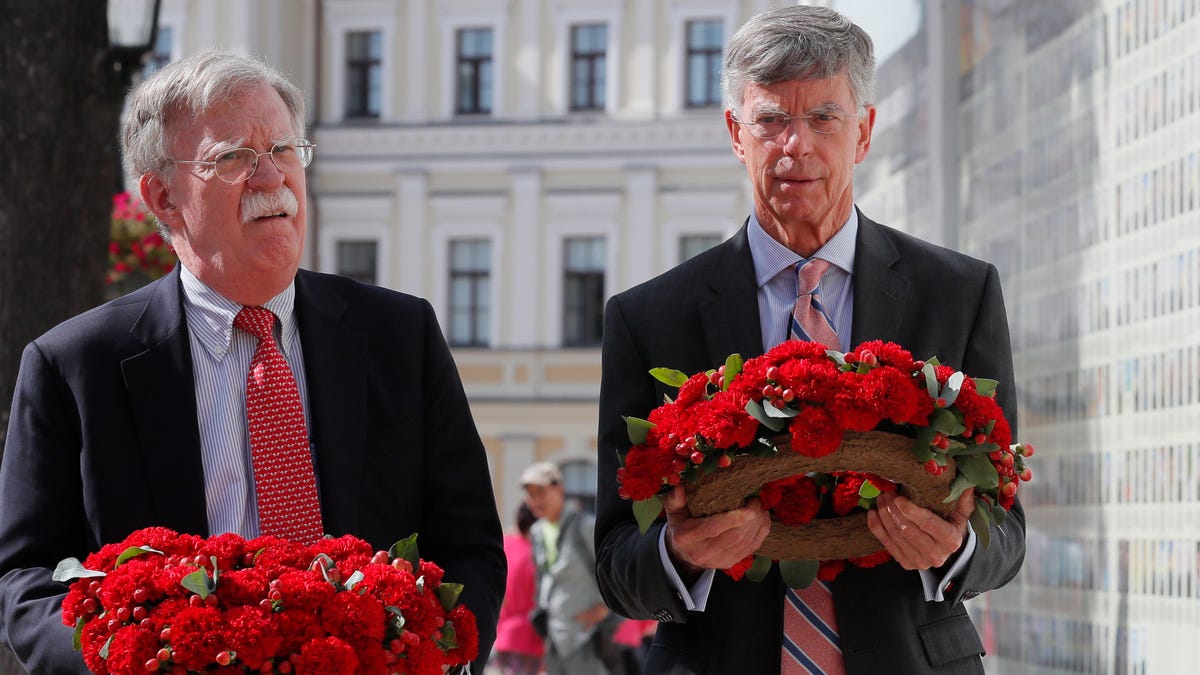 John Bolton (L), the US National Security Advisor and William Taylor (R), the US Ambassador to Ukraine, lays flowers to a wall with portraits of Ukrainian soldiers who were lost in the Eastern-Ukrainian conflict near of the St. Mikhail Cathedral in Kiev, Ukraine, 27 August 2019.