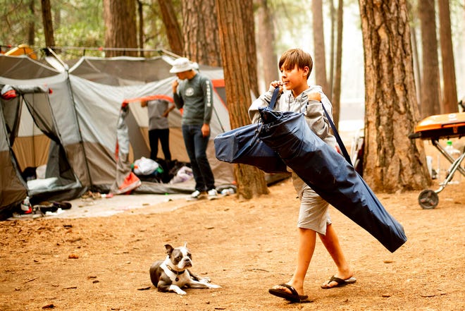 FILE - In this July 25, 2018, file photo, River Martinez, 10, breaks camp at the Upper Pines Campground in Yosemite National Park, Calif. The Interior Department is considering recommendations to modernize campgrounds within the National Park Service. (AP Photo/Noah Berger, File)