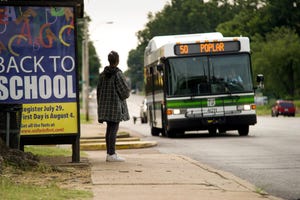 A rider waits to board a bus at a MATA stop on Poplar Ave. near Cleveland.