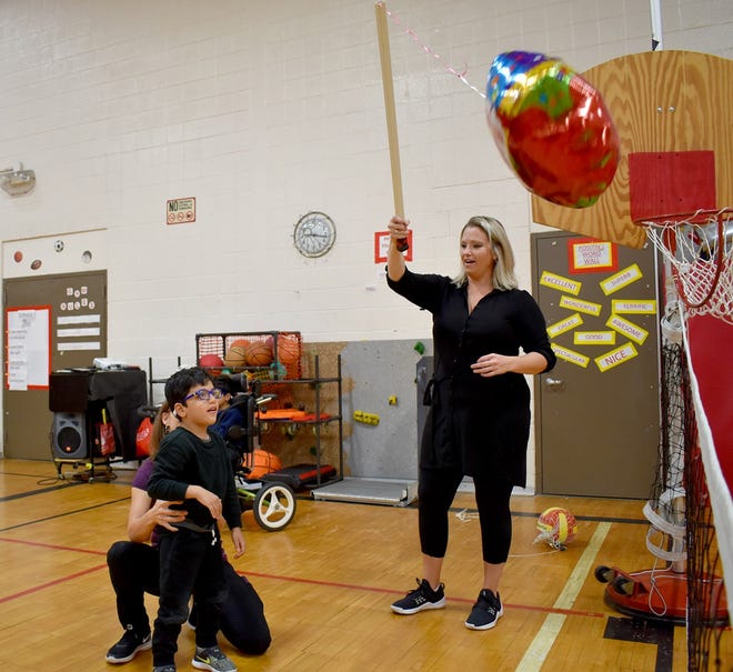Cooke School adaptive physical education teacher Elizabeth Adams works with a student Monday morning.