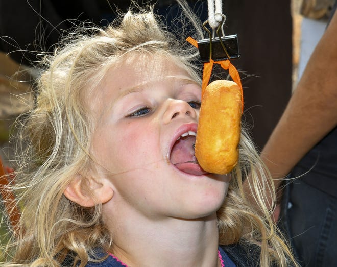 Emma Whitaker, 5, of Fallon tries to bite a donut without using her hands.