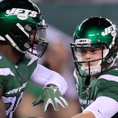 New York Jets quarterback Sam Darnold hands the ba
