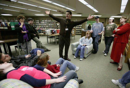 Ken Bignotti, center, a teen services librarian at Livonia's Alfred Noble Library at 32901 Plymouth Road in Livonia shows members of the Livonia Teen Advisory Committee where they can hang a mobile in the teen area of the library in this Wednesday, February 25, 2004 photo.