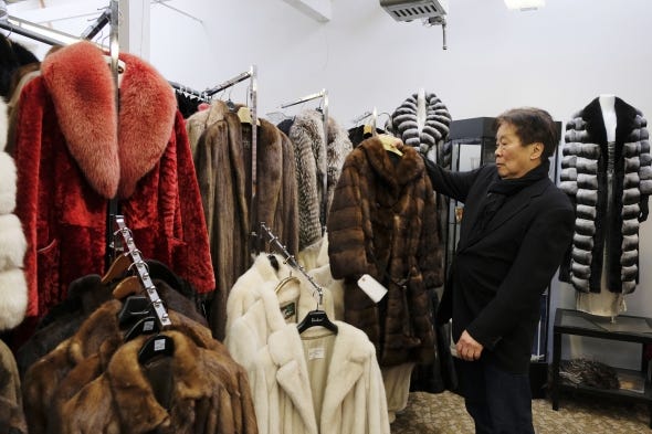 In this file photo taken Friday, March 16, 2018, Benjamin Lin holds up a fur coat at the B.B. Hawk showroom in San Francisco. At the time, San Francisco became the largest U.S. city to ban the sale of fur items in March 2018.