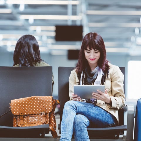 Young woman using tablet pc at international airpo
