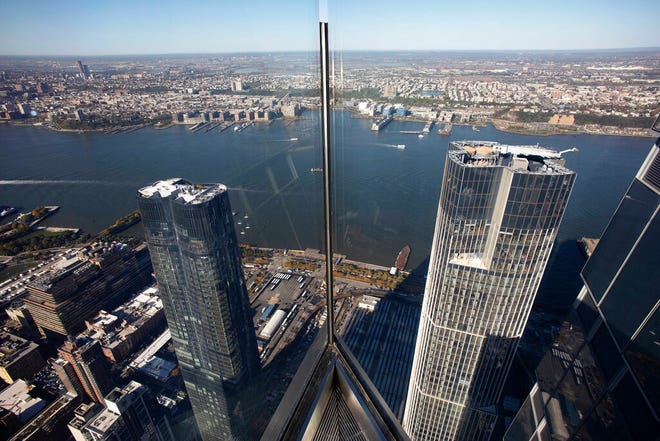 In this view from "Edge" buildings in Manhattan, foreground, the Hudson River, and New Jersey, background, are seen through thick glass panels, Thursday, Oct. 24, 2019 in New York. Thrill-seeking visitors at New York's Hudson Yards will be able to catch expansive views from the 100-story-high deck early next year.