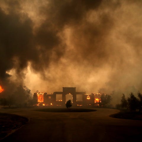 A structure burns after the Kincade Fire moved thr