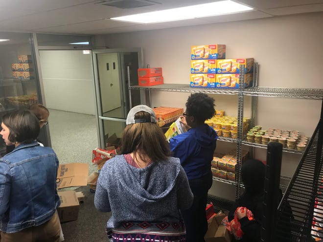 Students from the Inter-Club Council at the University of Memphis Lambuth Campus help stock the shelves at the food pantry.