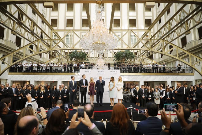 Then, presidential candidate Donald Trump and his family, from left, son Donald Trump Jr, son Eric Trump, wife Melania Trump and daughters Tiffany Trump and Ivanka Trump prepare to prepare the tape at the new Trump International Hotel October 26, 2016 in Washington sever, DC The U.S. federal government granted the Trump Organization a 60-year lease on the historic building before the billionaire New York real estate mogul announced his intention to run for president.