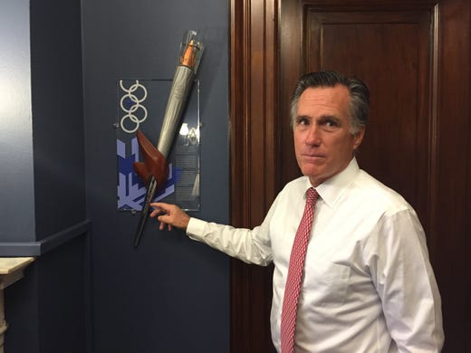 Sen. Mitt Romney shows off the Olympic torch in his Senate office