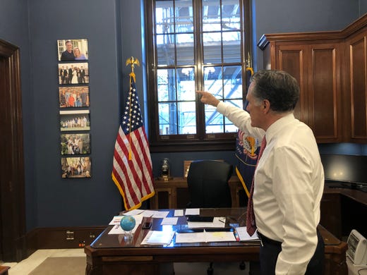 Sen. Mitt Romney points to family pictures on the wall of his Senate office