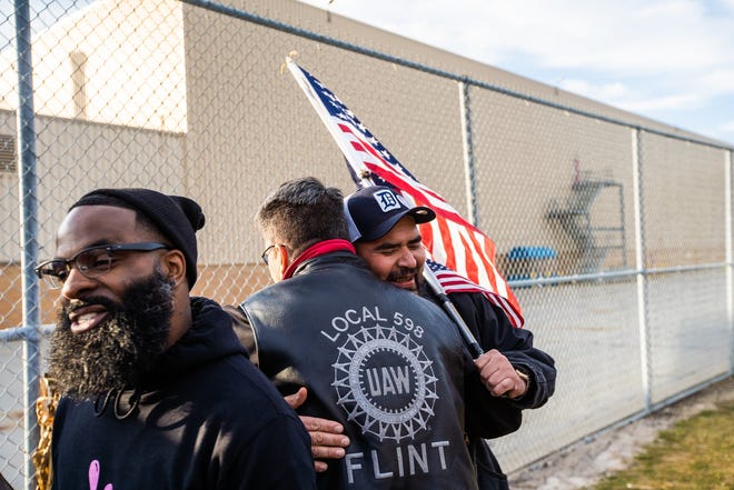 Flint Assembly Electrician Mike Perez (right) celebrates with others outside of Flint Assembly after UAW ratified their contract with General Motors marking the end of the strike on Friday, October 25, 2019.  