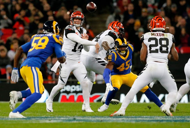 Cincinnati Bengals quarterback Andy Dalton (14) throws a short pass over the middle to running back Joe Mixon (28) in the second quarter of the NFL Week 8 game between the Los Angeles Rams and the Cincinnati Bengals at Wembley Stadium in Wembley, London, on Sunday, Oct. 27, 2019. 