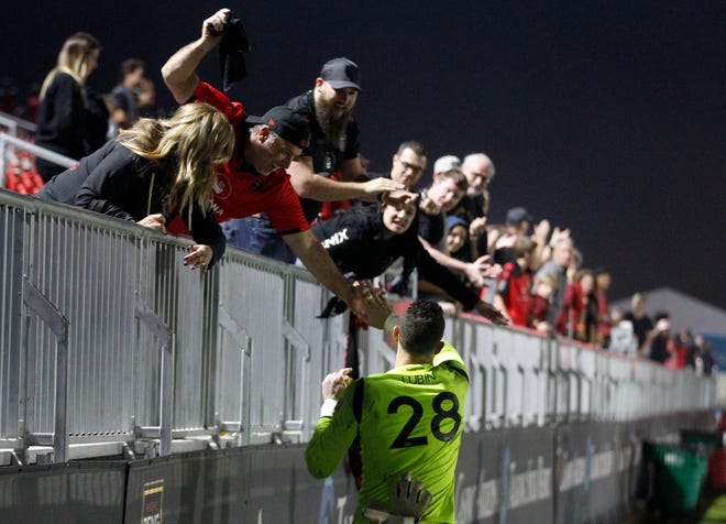 Phoenix Rising fans slap high fives with goalie Zac Lubin after their overtime shootout win over Austin Bold at Casino Arizona Field.