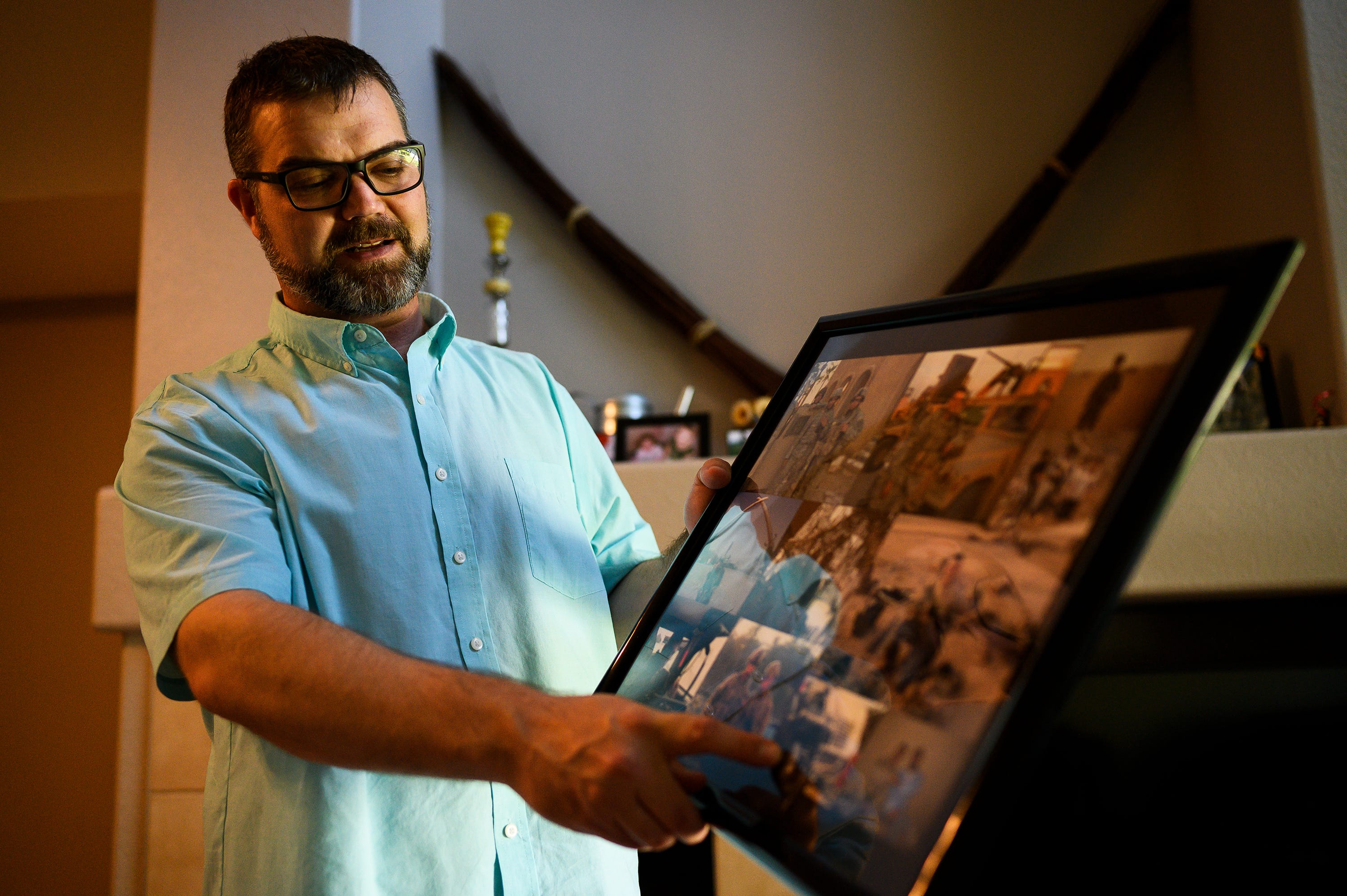 Michael Haring, an Army veteran, shows photographs of when he served in Iraq inside his townhouse in Longmont, Colorado.