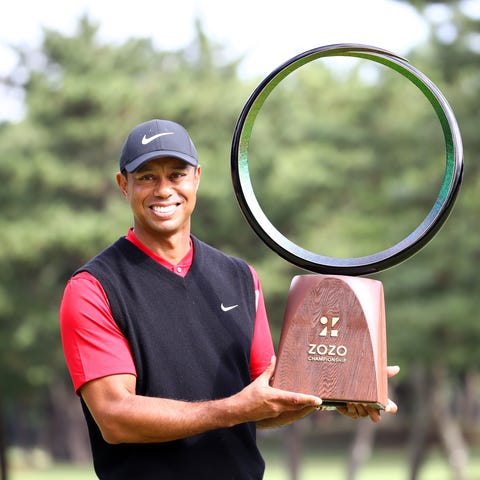Tiger Woods poses with his trophy after winning th