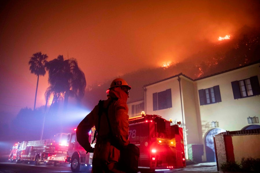A firefighter watches a flames approach the Mandeville Canyon neighborhood during the Getty fire, Oct. 28, 2019, in Los Angeles.