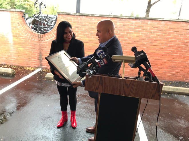 Mary Concepcion receives a proclamation from Camden Mayor Frank Moran at a ribbon cutting for the Cooper Plaza Townhomes, which underwent a $14 million renovation.