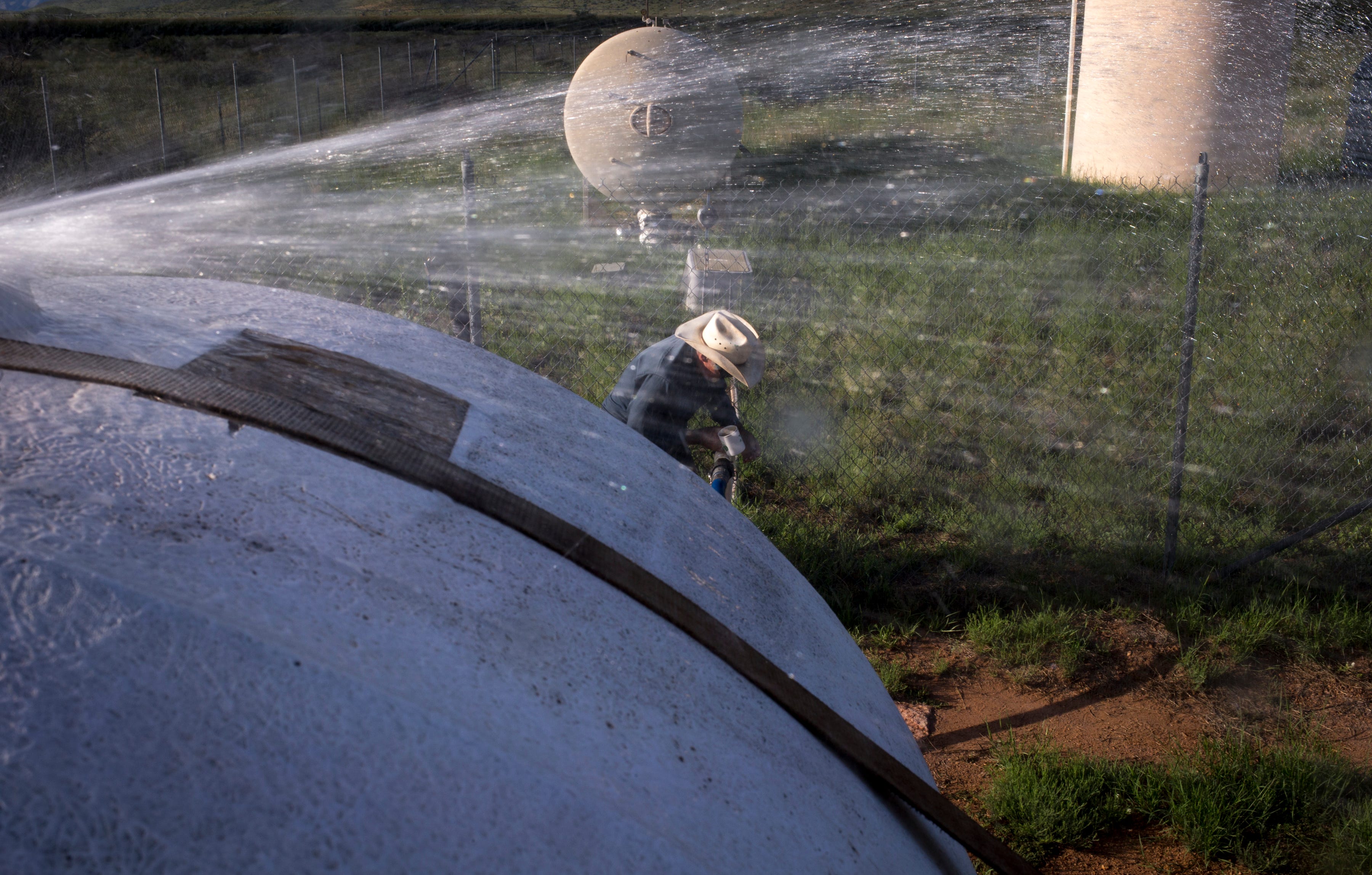 Dean Bales turns off the water on his well after filling the 1,500-gallon tank on his water truck near Sunizona.