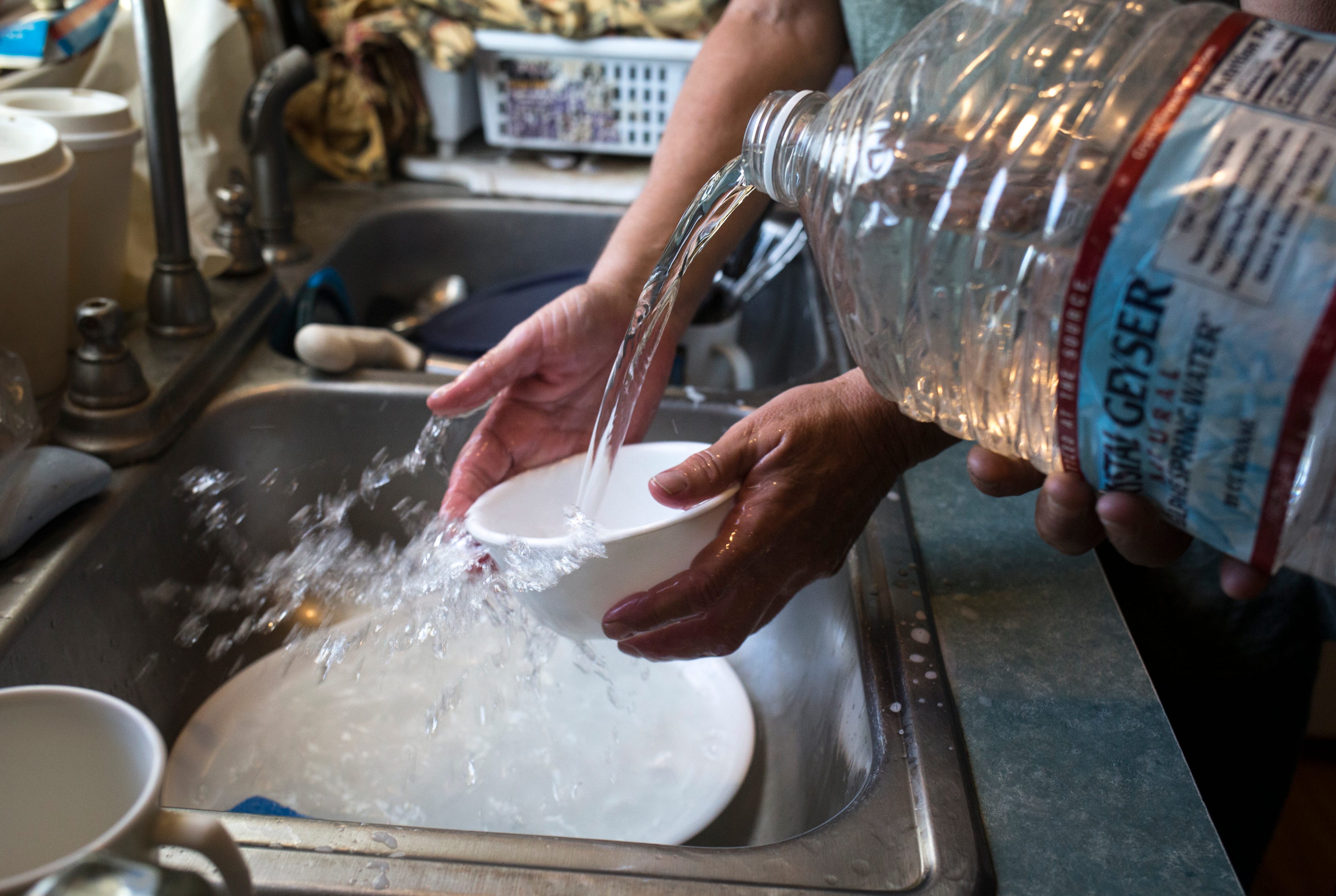 Nancy Blevins and her husband, Rodney Hayes rinse dishes, Aug. 28, 2019, in the kitchen of their home in Vicksburg, Arizona.