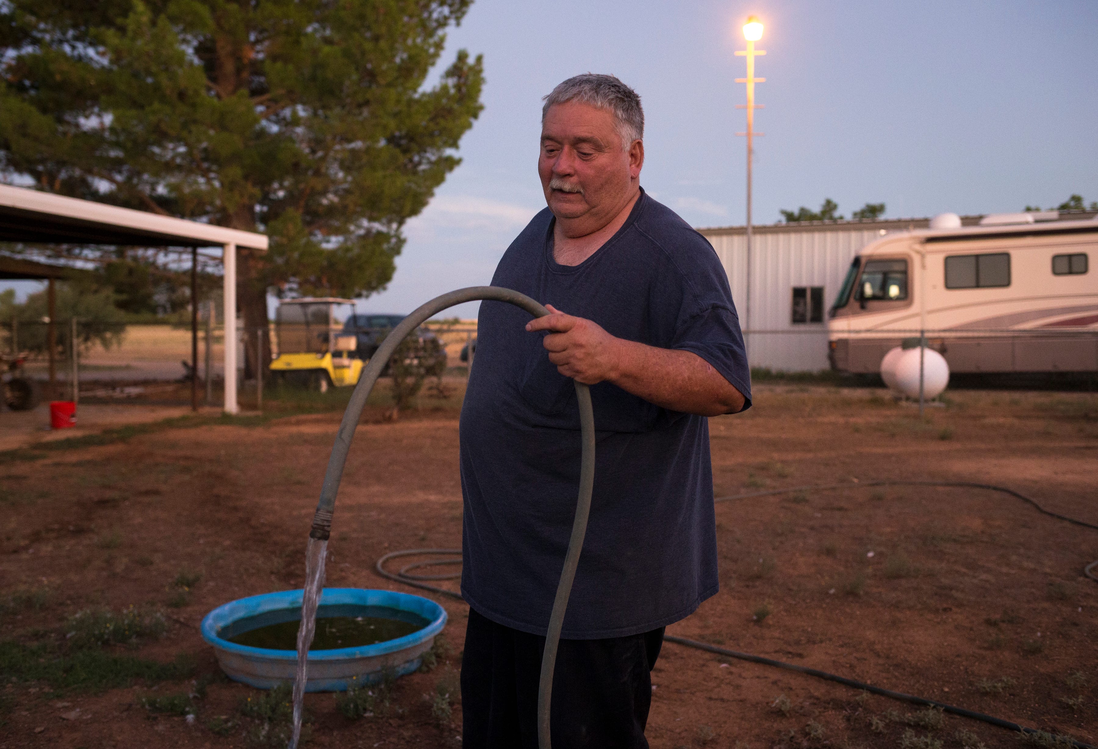 Richard Wilson waters his animals, August 13, 2019, at his home in Cochise, Arizona. Wilson’s well went dry and he is now hauling water to his property.