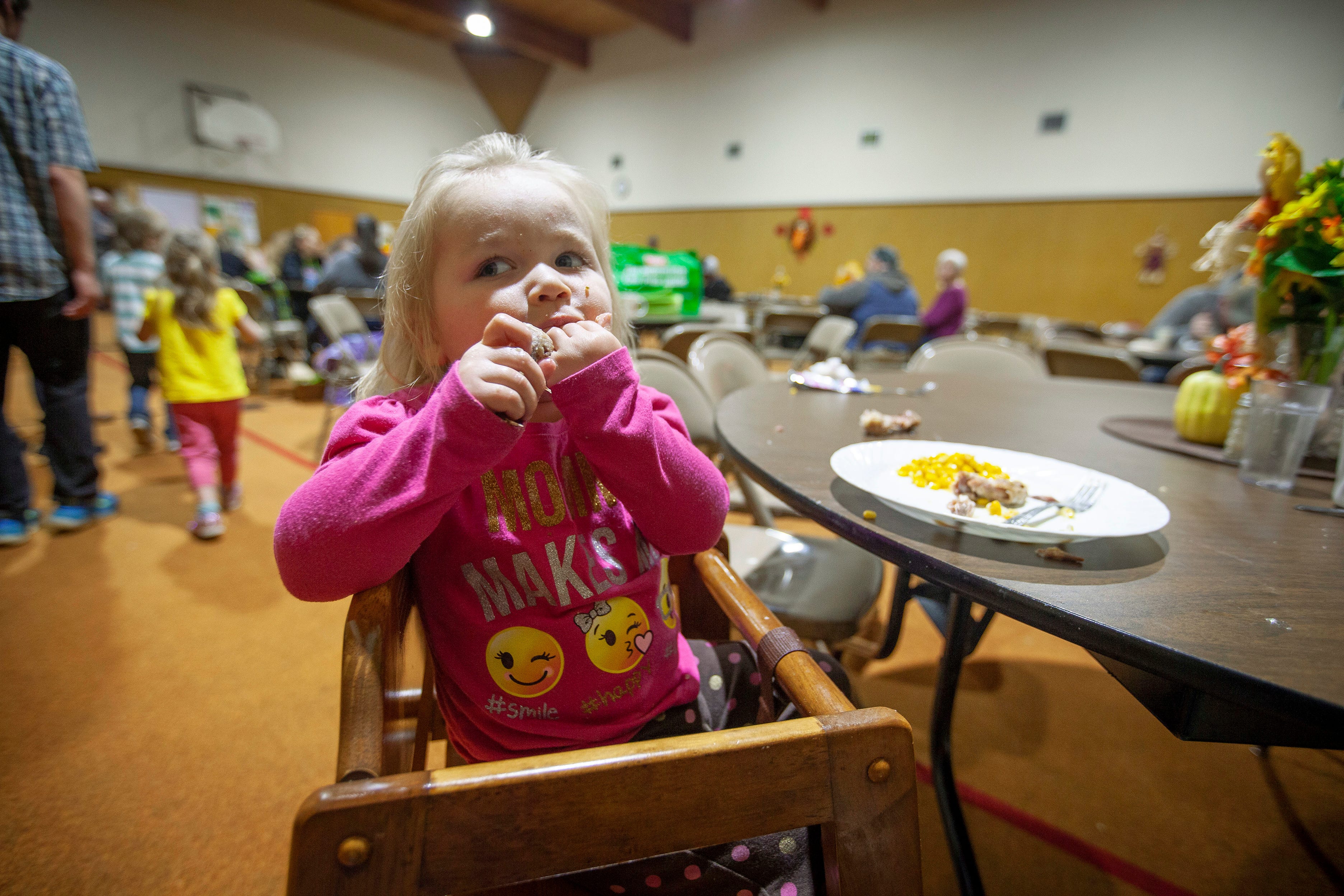 Freyja James, 2, of Salem, finishes the meal she and her family received from South Salem Friends. After the meal, clients have fresh fruits and vegetables available for them to take home.