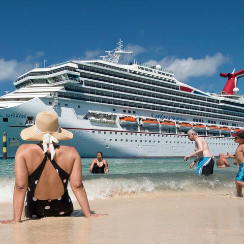 Guests enjoy the beach while the Carnival Sunrise 