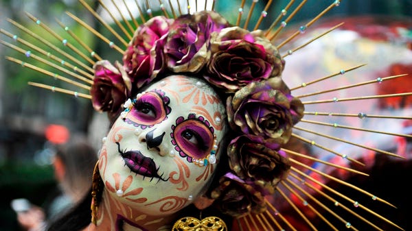 A woman fancy dressed as Catrina takes part in the
