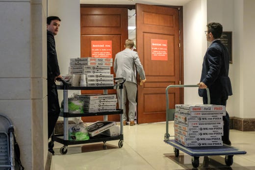 Staffers deliver pizza to a closed session before the House Intelligence, Foreign Affairs and Oversight committees on Capitol Hill on Oct. 23, 2019 in Washington, DC.