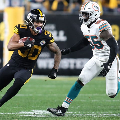 James Conner carries the ball against the Dolphins