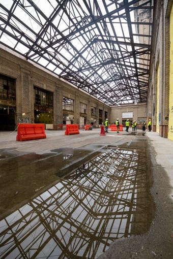 Water puddles on the floor below the open-to-the-elements atrium inside the Michigan Central Depot.