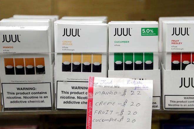 In this Thursday, Dec. 20, 2018 file photo, Juul products are displayed at a smoke shop in New York. On Thursday, Oct. 17, 2019, the company announced it will voluntarily stop selling its fruit and dessert-flavored vaping pods.