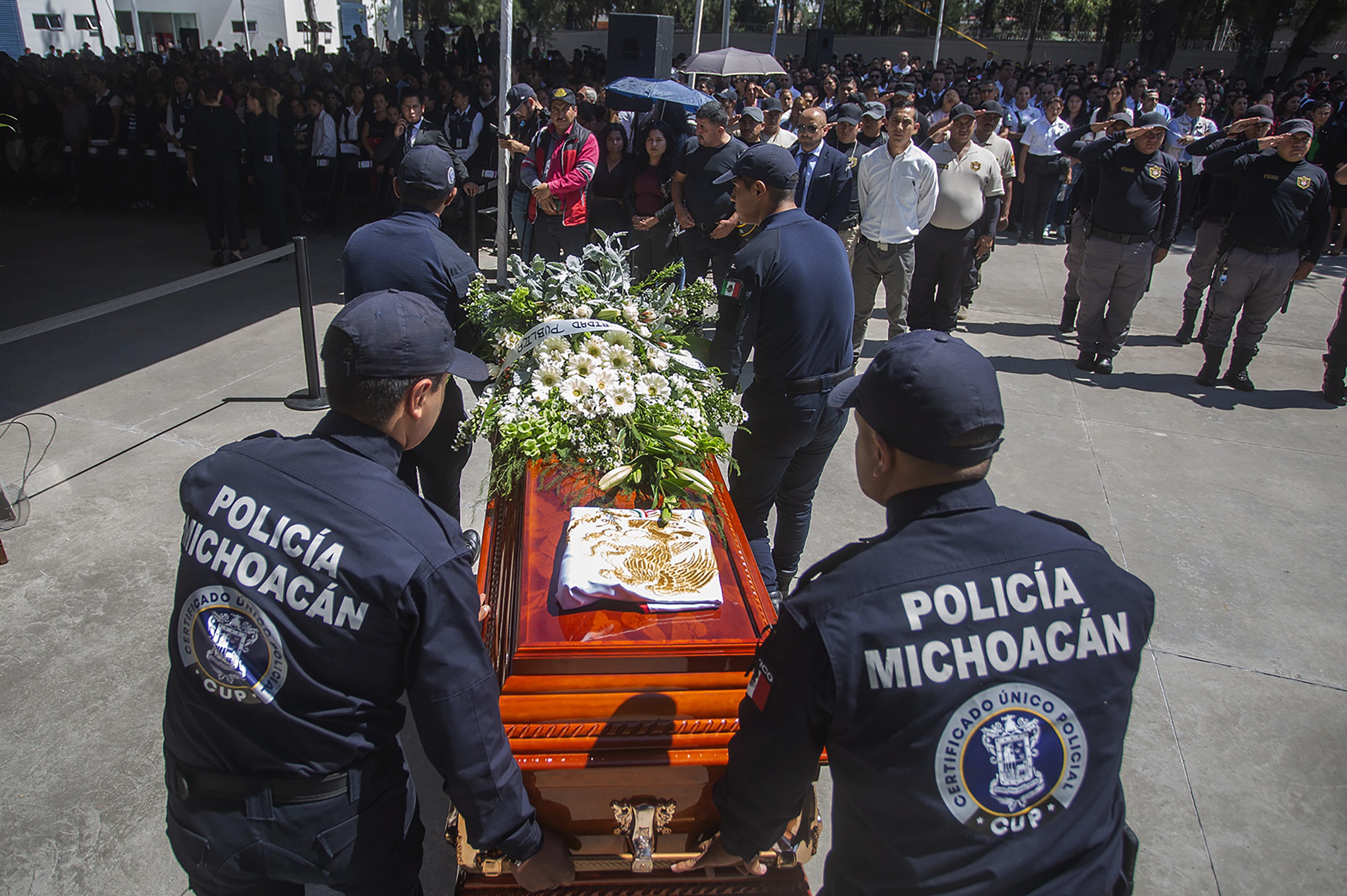 Relatives and members of the Michoacán police department pay tribute to 13 officers killed in an ambush on Oct. 14, 2019.