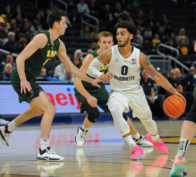 Marquette guard Markus Howard looks for space in the lane around St. Norbert guard Jack Pettit on Tuesday.