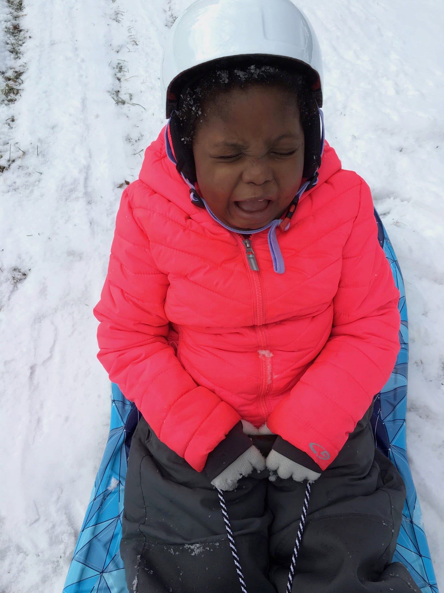 Chika makes a funny face while sledding.